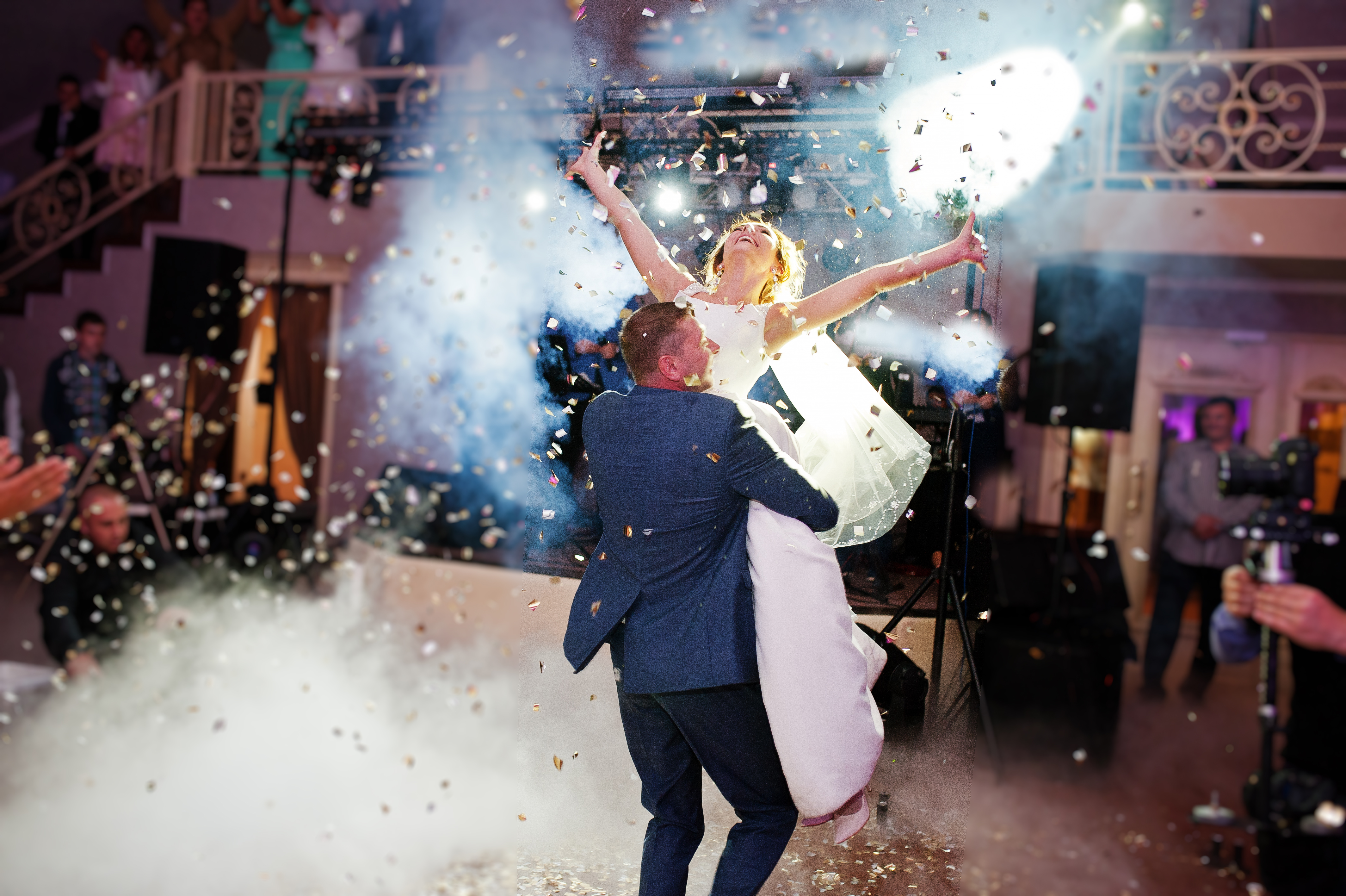 Newlyweds celebrating with cannon confetti and dramatic stage light