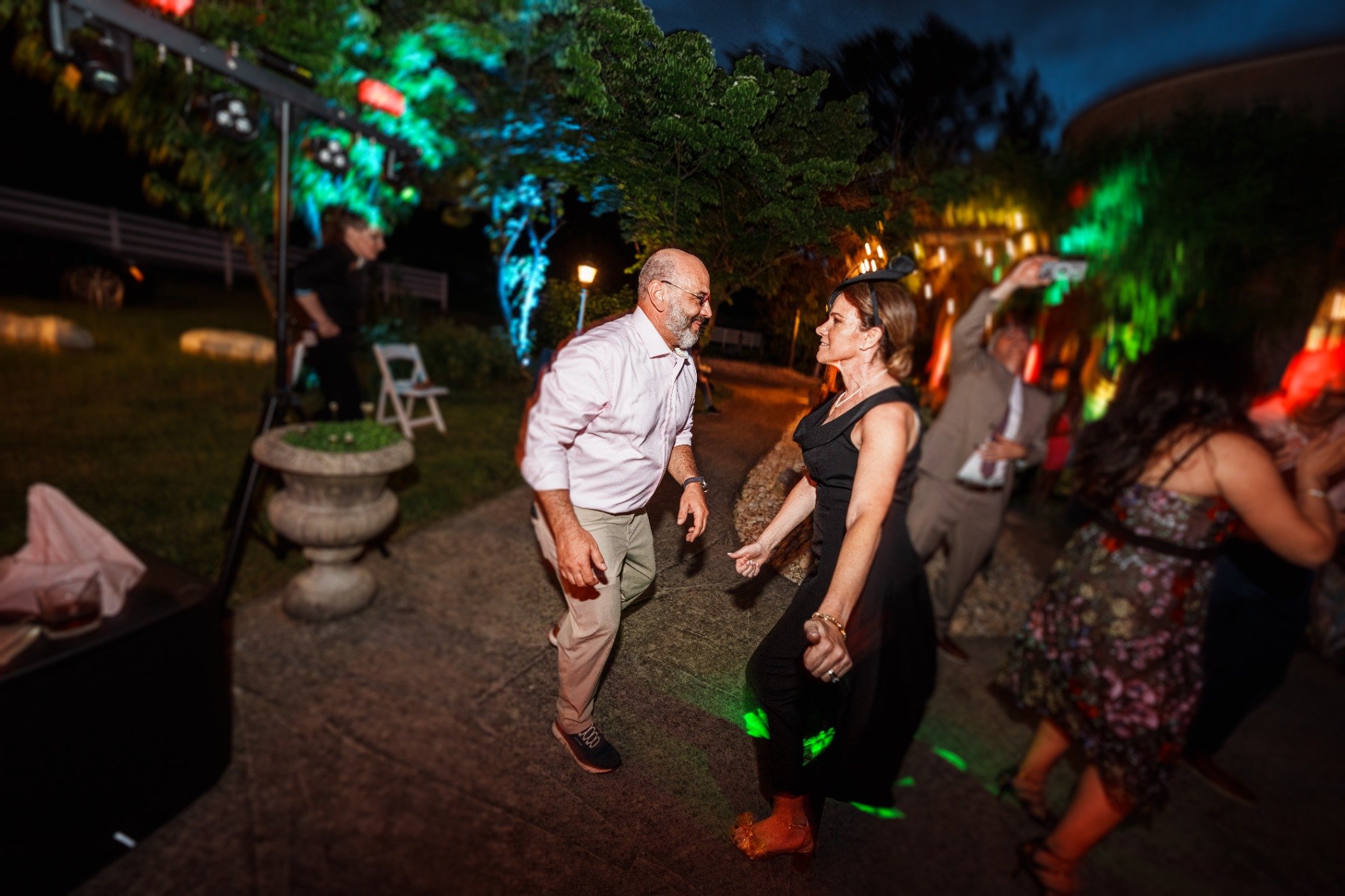 Wedding guests dancing under colored stage lighting at an Atlanta Music Pros reception